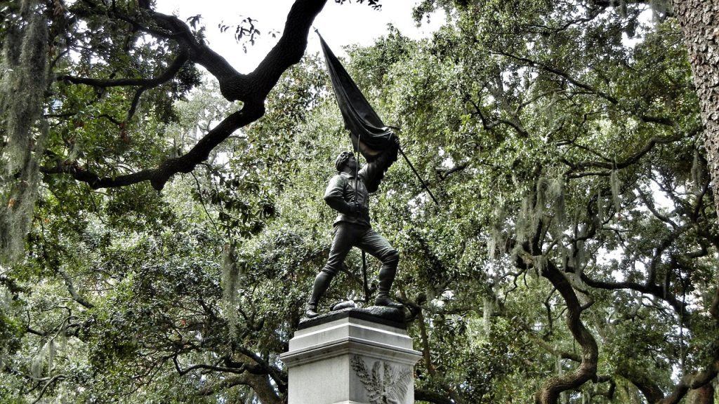 Soldier statue holding a raised flag in a Savannah park